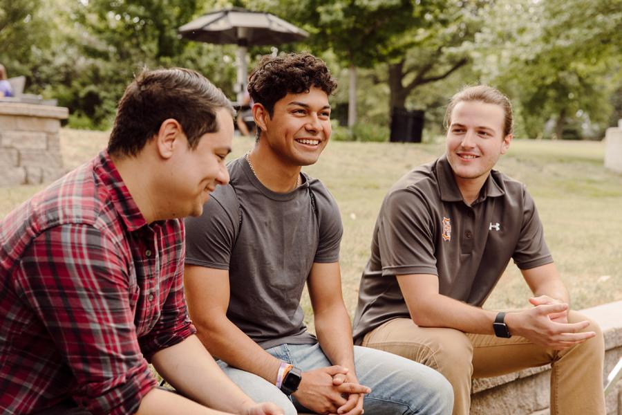 prospective students having a conversation on a bench